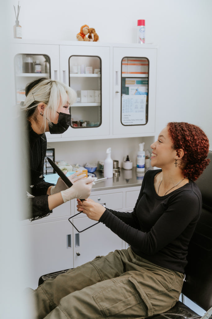 pheenix-piercing-team-member-talking-with-client-at-body-piercing-studio-about-aftercare-for-piercings